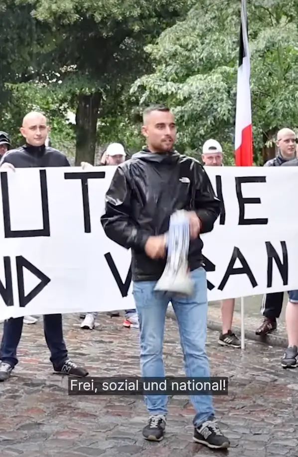 Un homme qui manifeste tient un mégaphone à la main et crie « Libre, social et national ! »