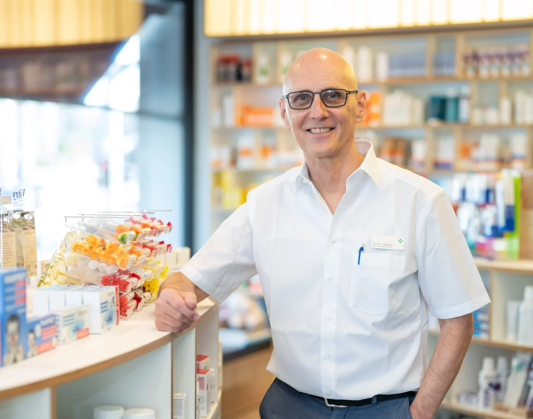 Thomas Kappeler se tient dans la pharmacie, un bras appuyé sur le comptoir.