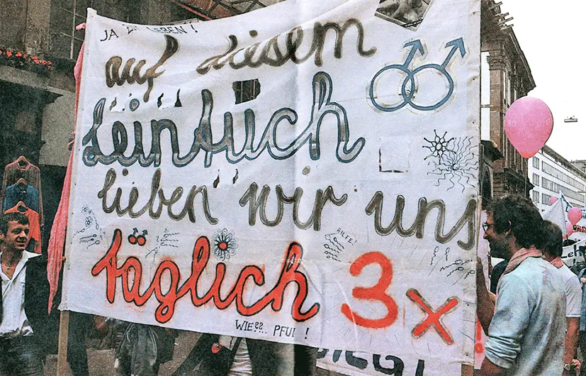 Des personnes lors du défilé tiennent un drap portant l'inscription «Auf diesem Leintuch lieben nur uns. Täglich 3x» (Sur ce drap, on ne s'aime qu'entre nous. 3x par jour.)