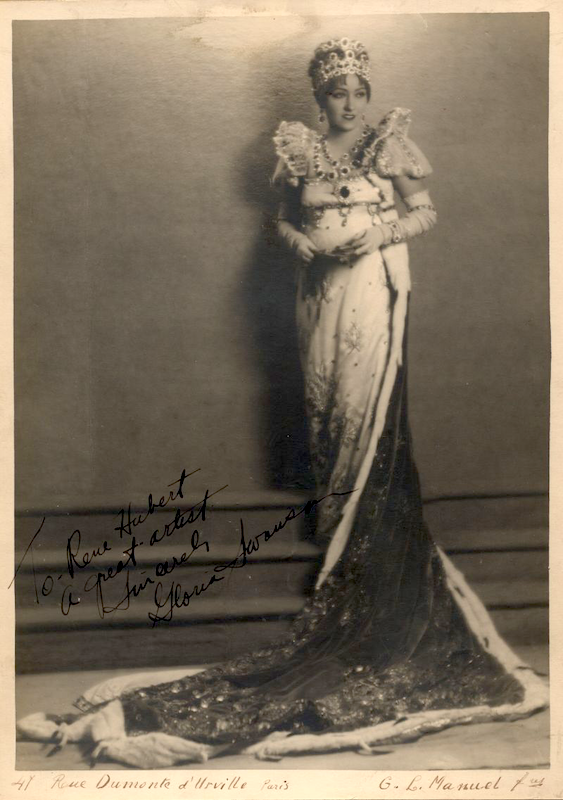 Eine Frau in einem formellen Kleid mit einem herabfließenden Königinnenumhang und einer Krone