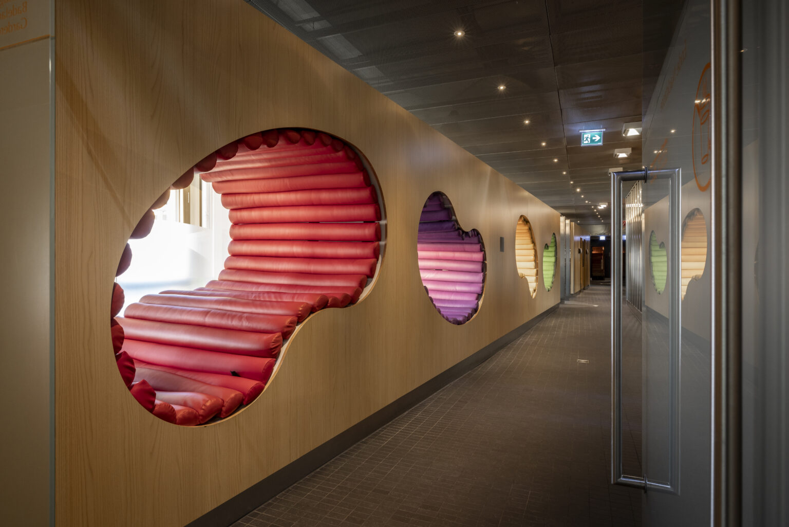 Bunte Liege-Cocons in einer Holzwand im Wellnessbereich des Puls 5